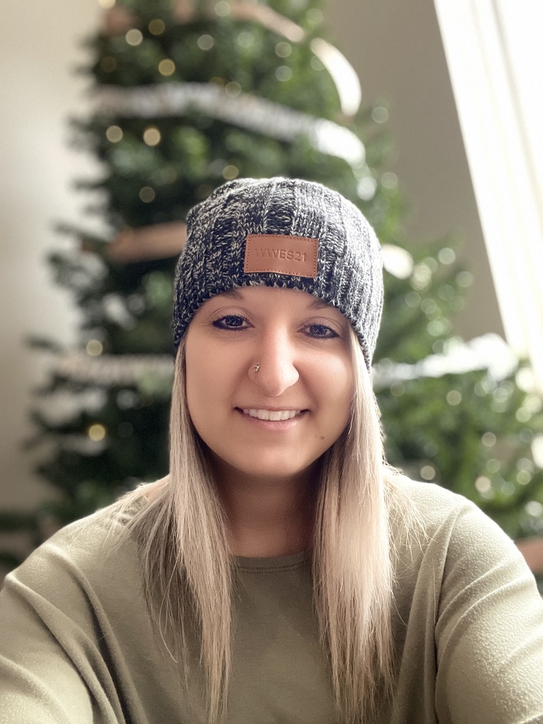 Sam, founder of Sidequest Studio, smiling in a knit hat